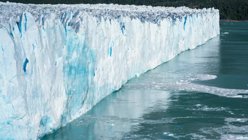 Ice calves off a glacier during the day