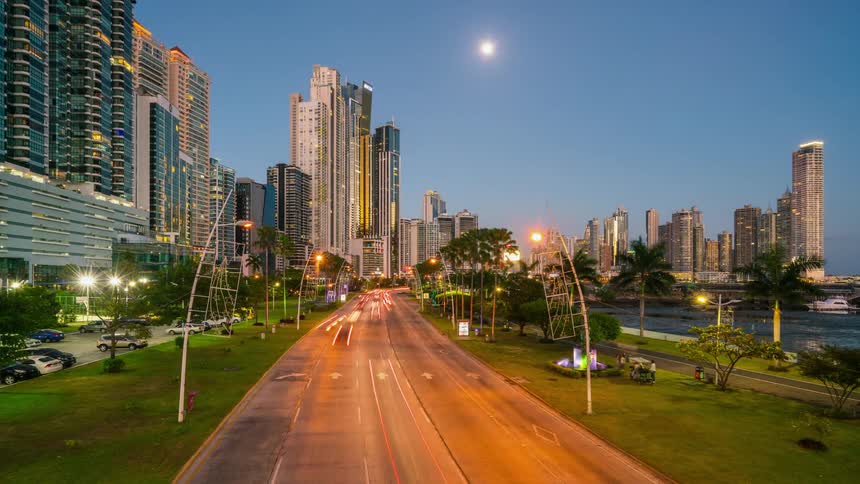 The cars speed along the road by the city