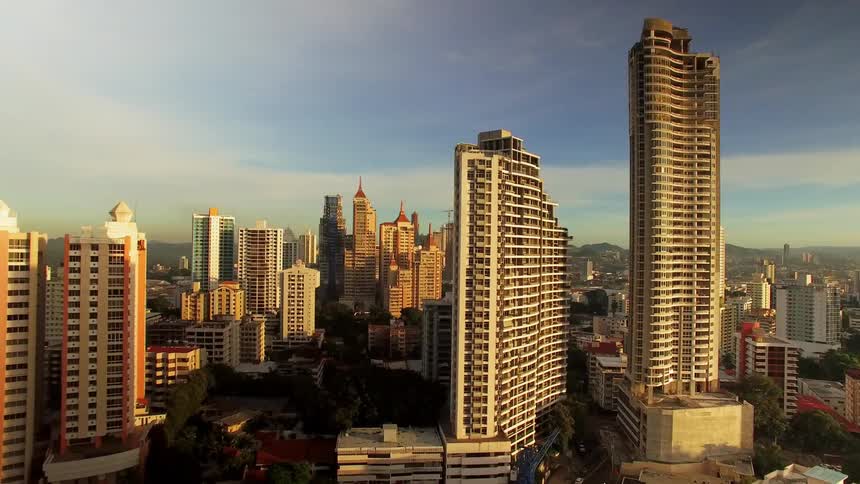 The tall buildings reach into the cloudy sky