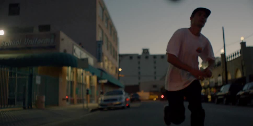 A man runs and drops his skateboard on the street then rides