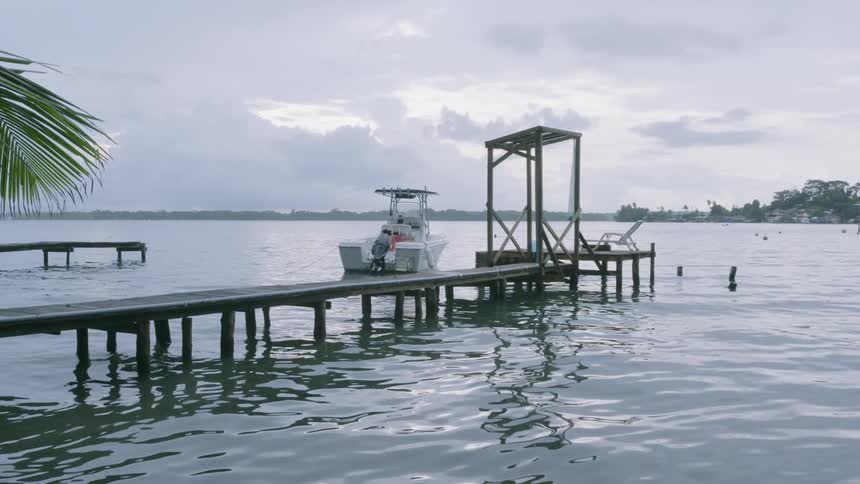 A boat is docked by the pier on a cloudy day in Bocas del Toro
