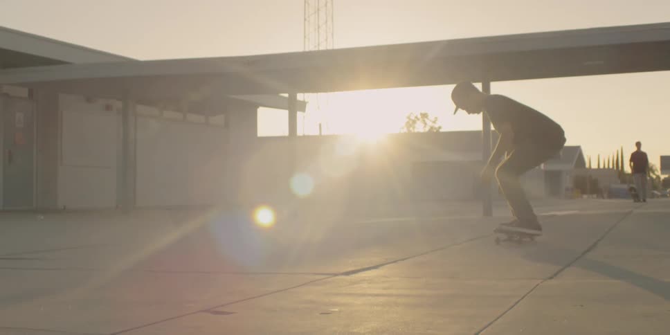 A man rides his skateboard then does a kick flip