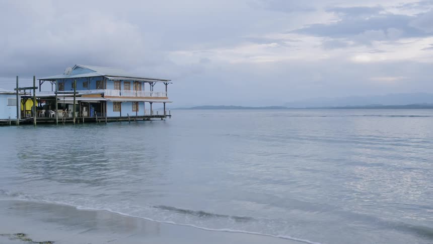 Waves come to shore around a stilt house