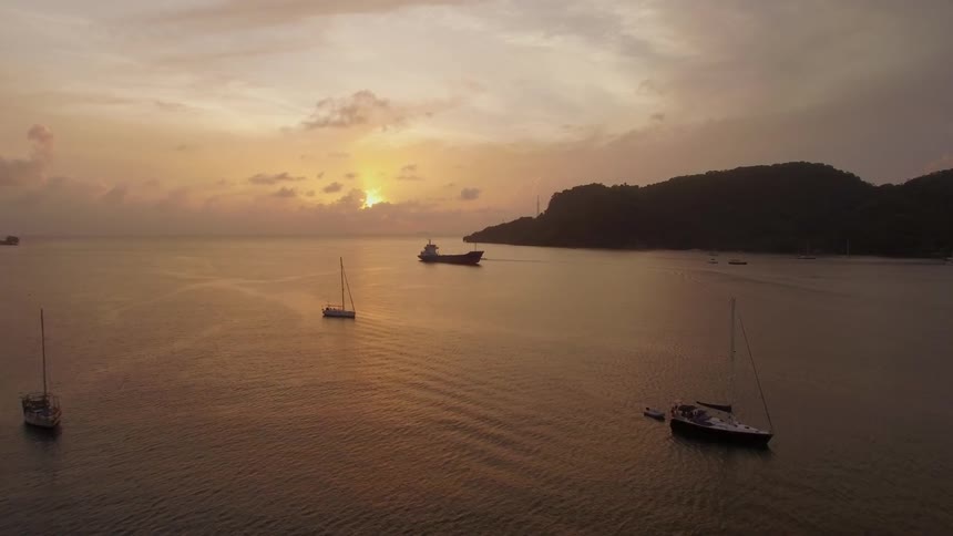 The boats are all still in the water at soothing colorful sunset