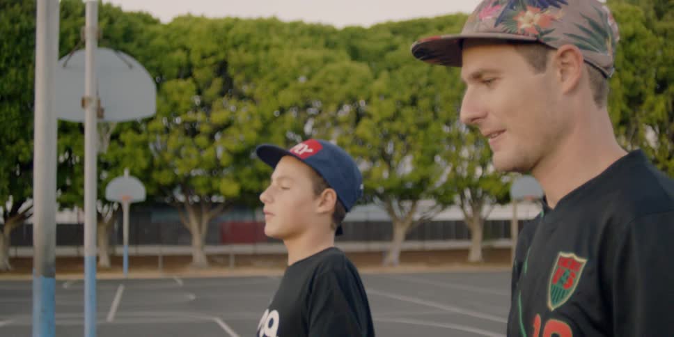 Brothers walk across an outdoor basketball court