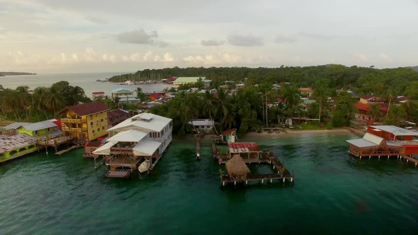 Colorful cabins and boat houses float on docks in a tropical resort in Panama