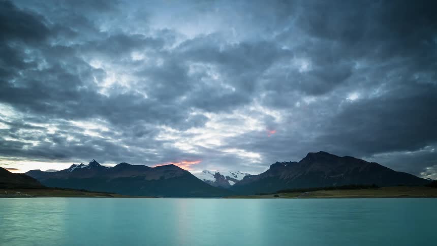 Clouds move over mountain peaks and ocean