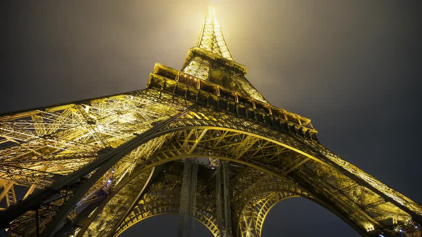Fog is drifting past the eiffel tower at night