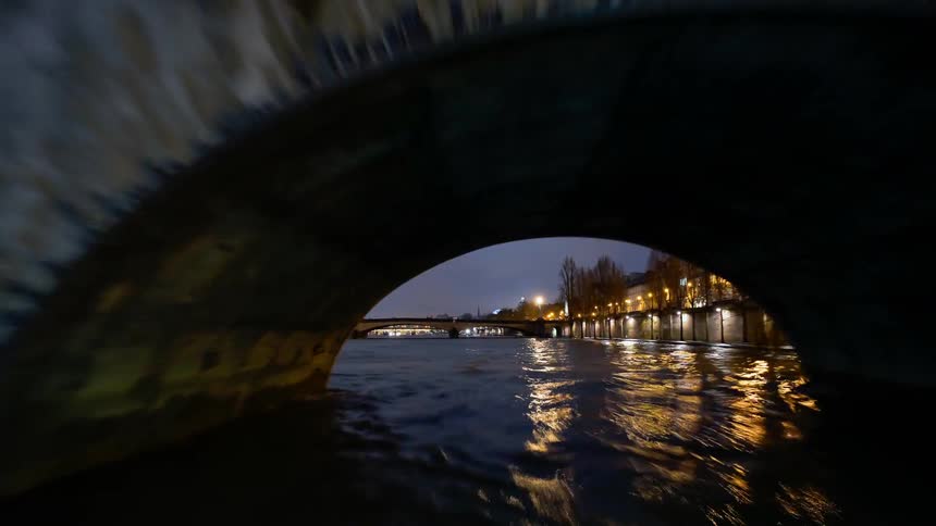Time-lapse moving down a river in a city area on a cloudy evening