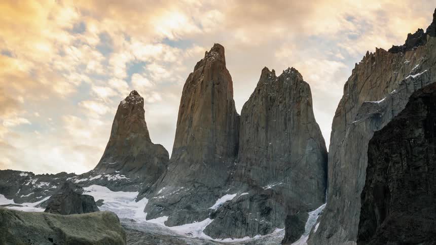 Clouds are drifting across mountain peaks during the day