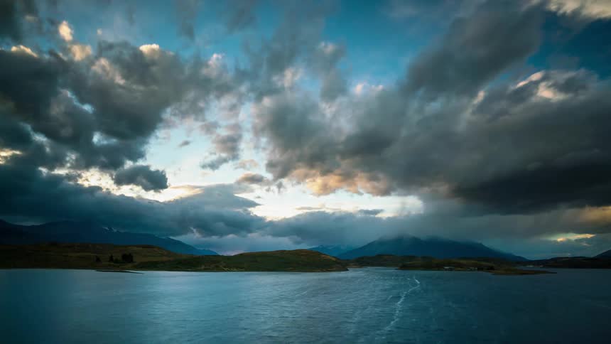 Clouds float over a mountain lake at sunset