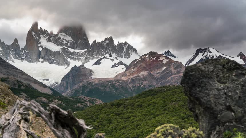 The clouds roll off the snow covered mountain