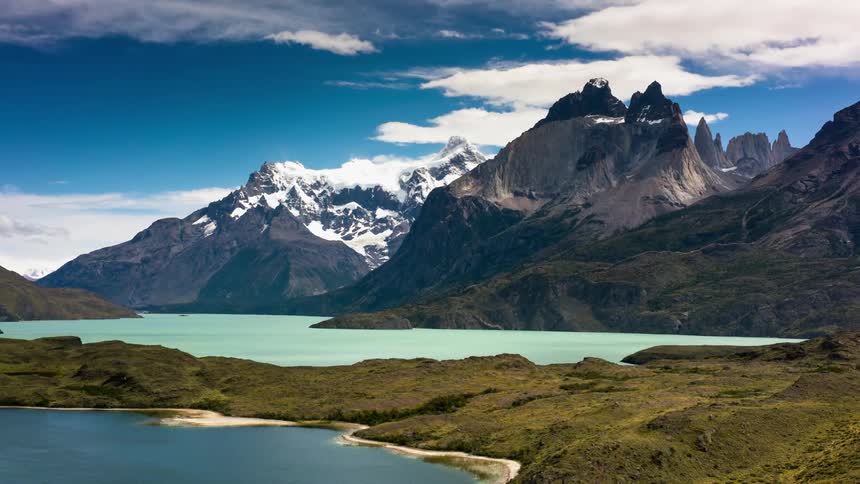 The water is calm near the mountain