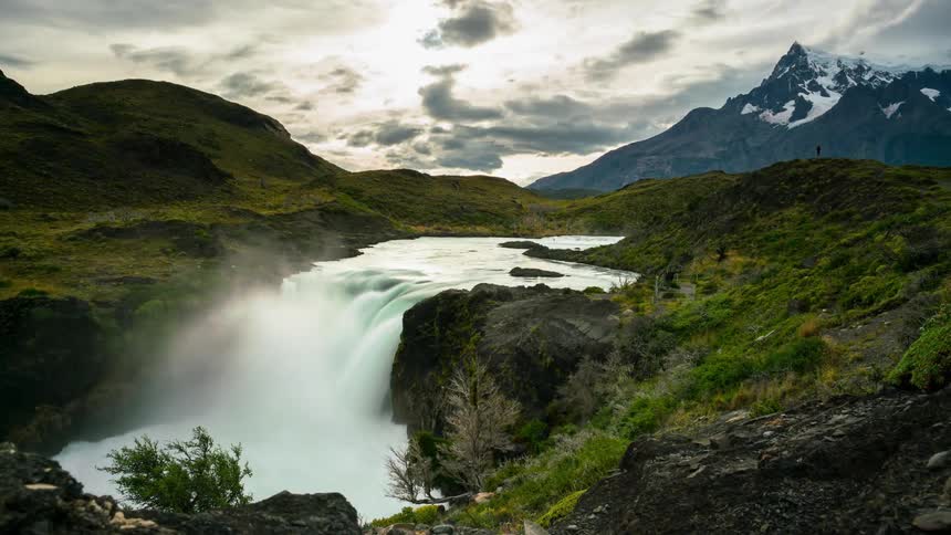Water in a river is cascading over a ledge during the day