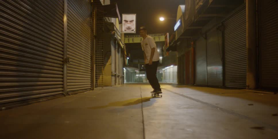 A man races jumping his skateboard in an alley