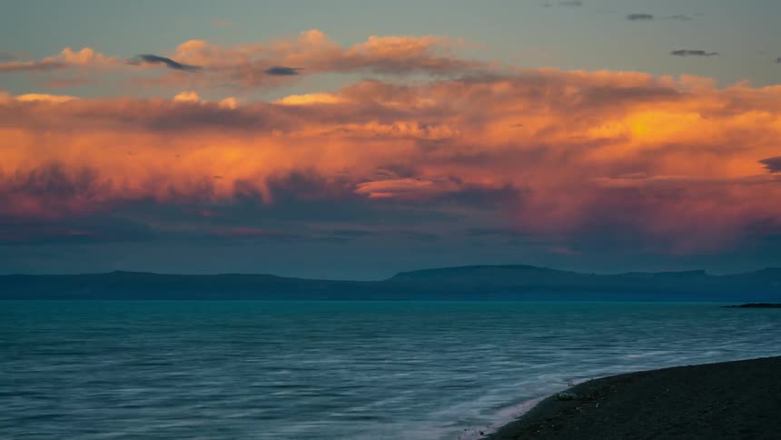 The waves crash against the shore at dawn