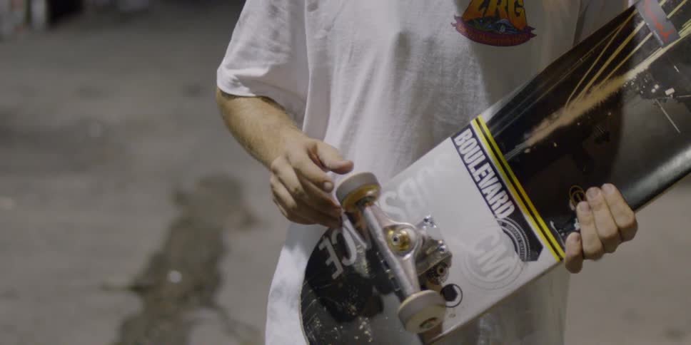 A man spins the wheels on a skateboard