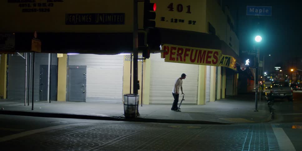 A man jumps on his skateboard riding off on the corner