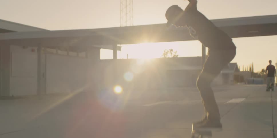 A man is jumping on his skateboard at sunset