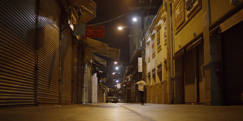 A man is skateboarding down the alley
