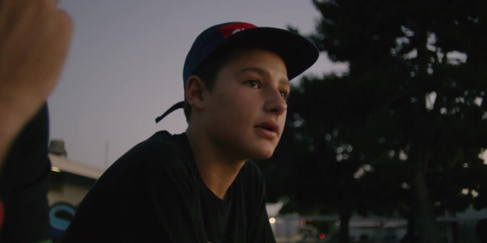 Teenagers are sitting and talking outside at dusk