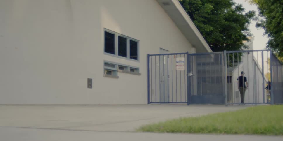 Two men run from the fence in the alley
