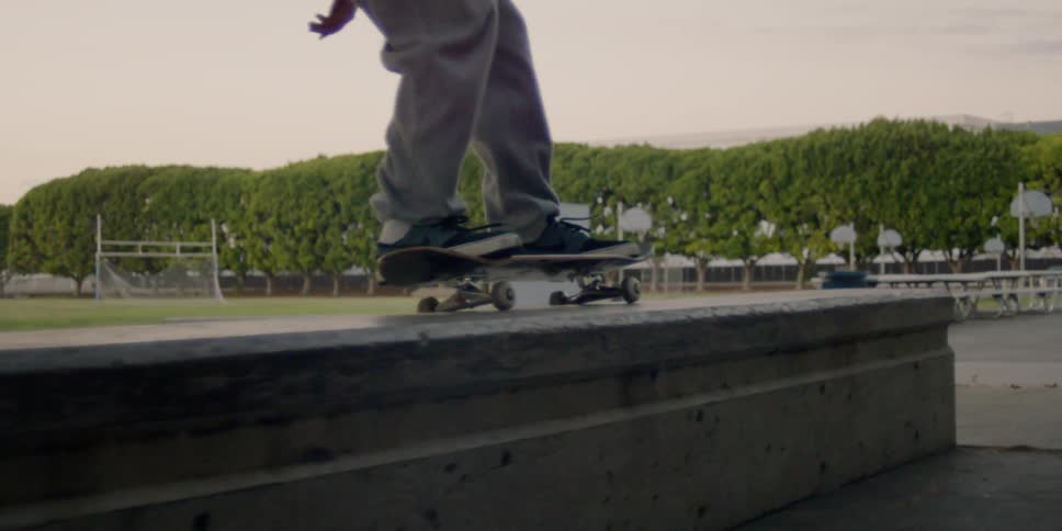 A skateboarder is jumping up and riding on a wall