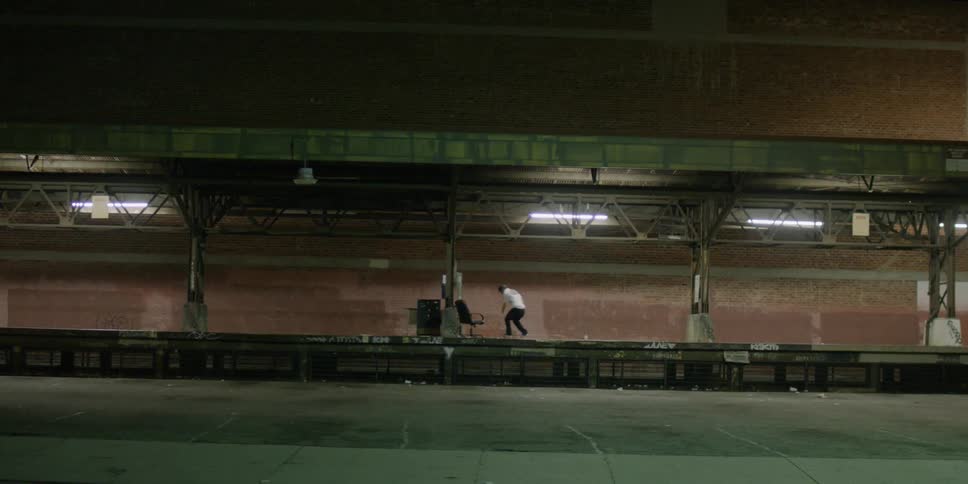 A man jumps on his skateboard on the platform