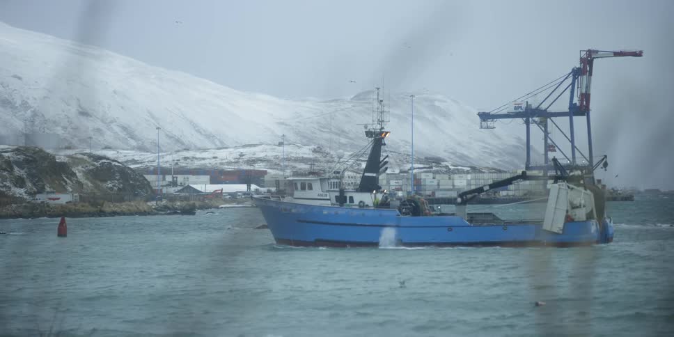 Large boat coming into a snowy shore