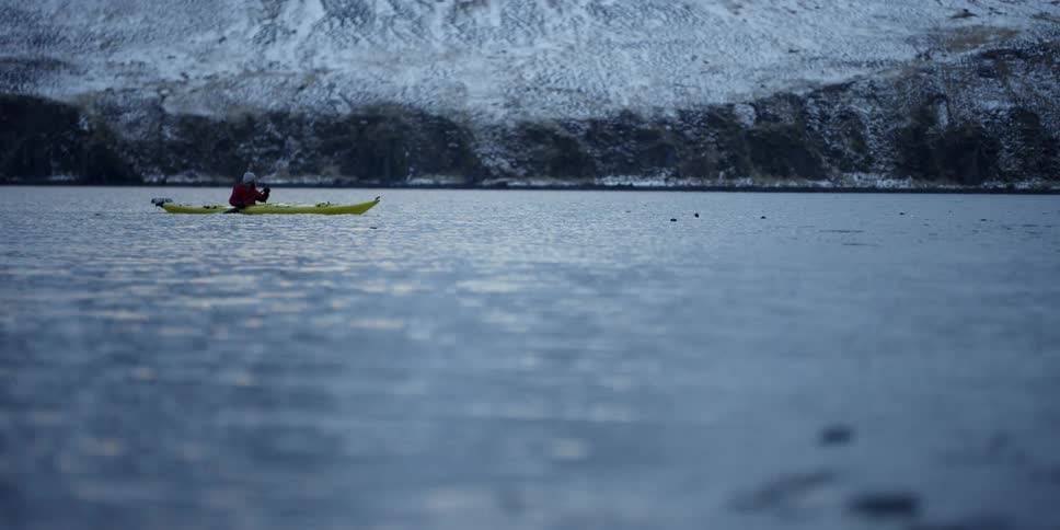 A man paddles a kayak on the sea