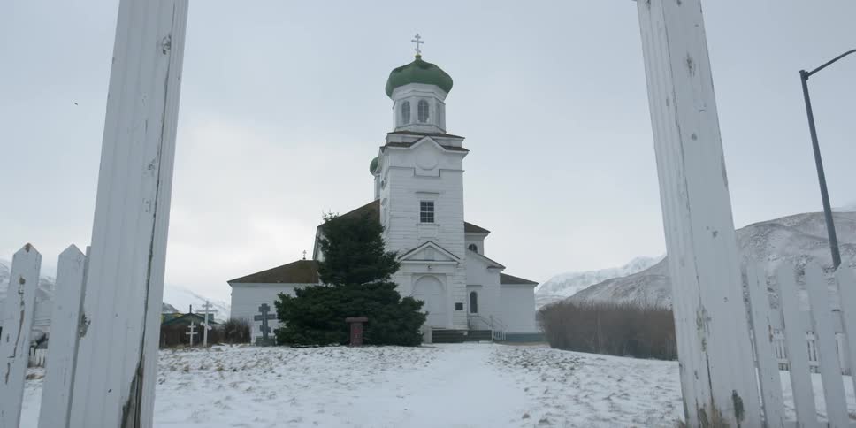Snow falls near a village church