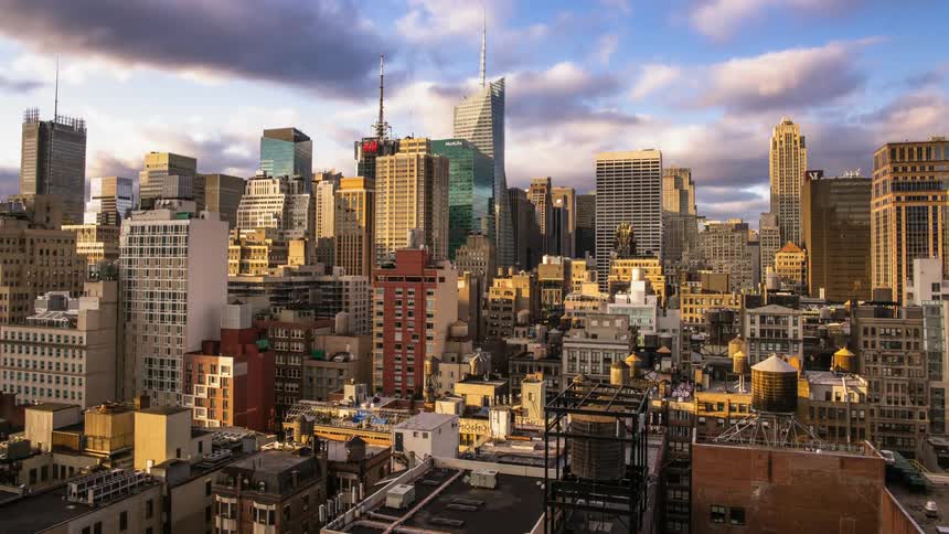 Clouds move over skyscrapers and rooftops of a city