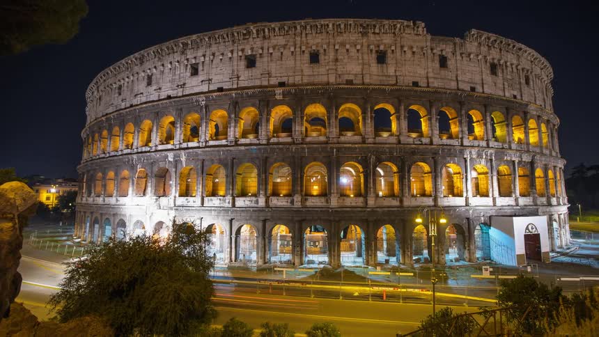 Vehicles passing in front of the Coliseum in Rome at night