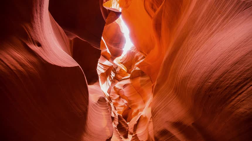Sunlight shines into a red rock canyon