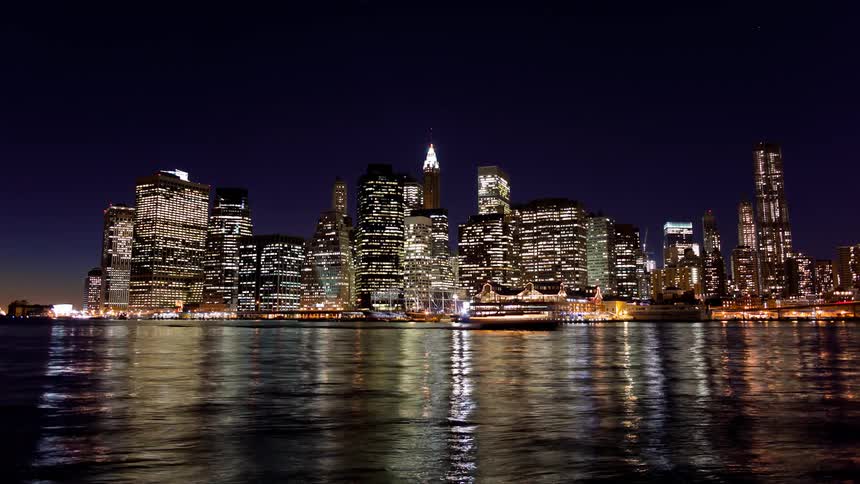 City lights illuminate the night sky near the water