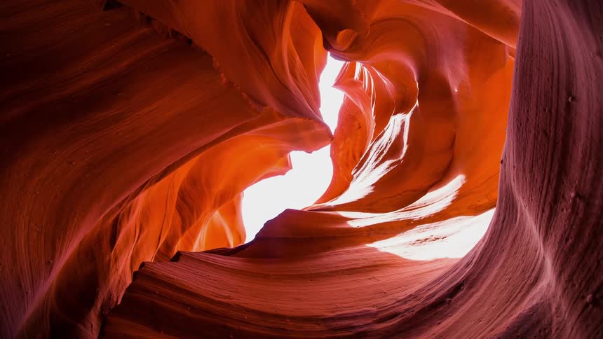 The sunlight shines through a curving slot canyon