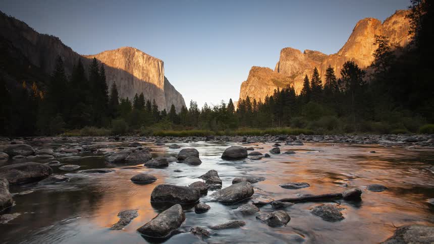 A river flows in mountains at sunset