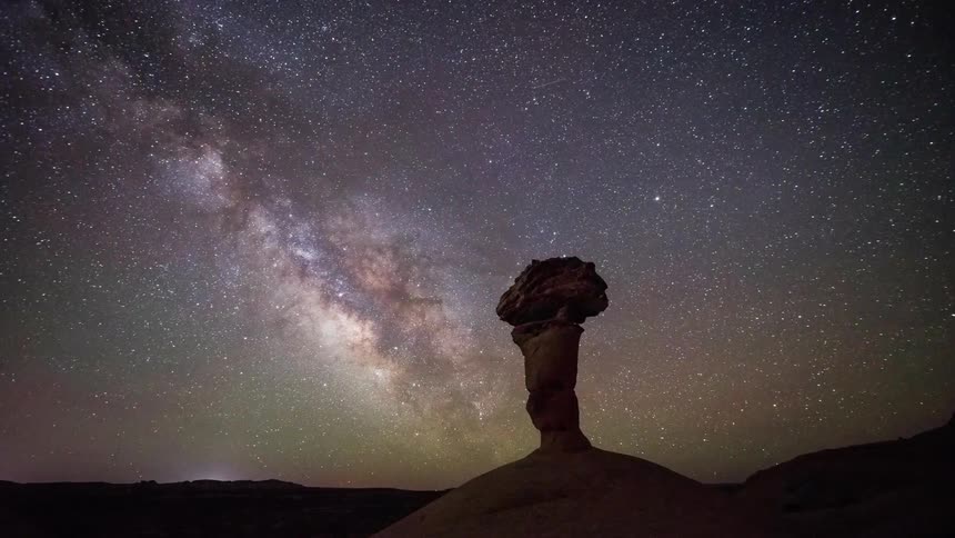 The stars light up the sky above a rock formation