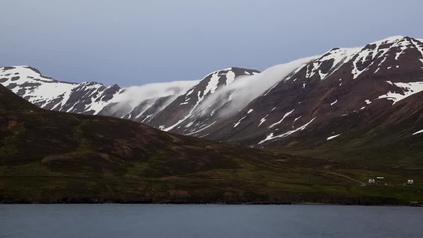 The clouds are moving over the top of the mountain