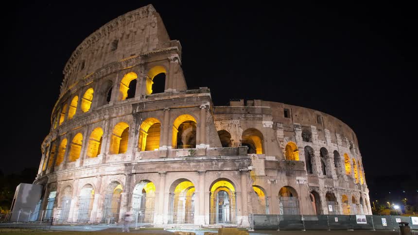 Lights illuminate the arches of the Colosseum at night