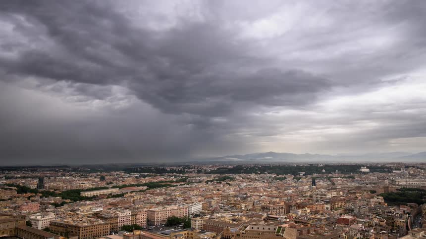 Dark clouds pass above a large city