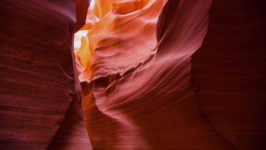 The sunlight shines into a curved slot canyon
