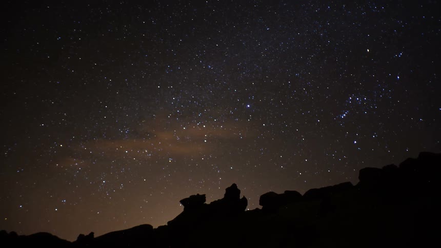 Stars move above rock formations