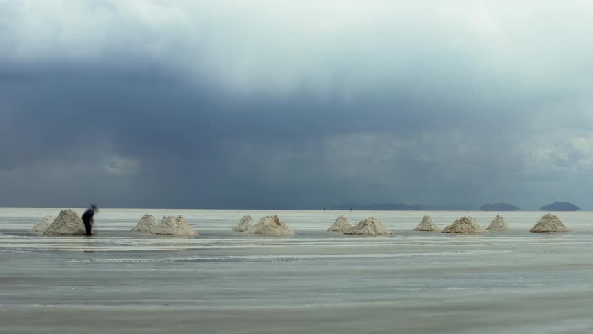 A person is shoveling salt on a cloudy day