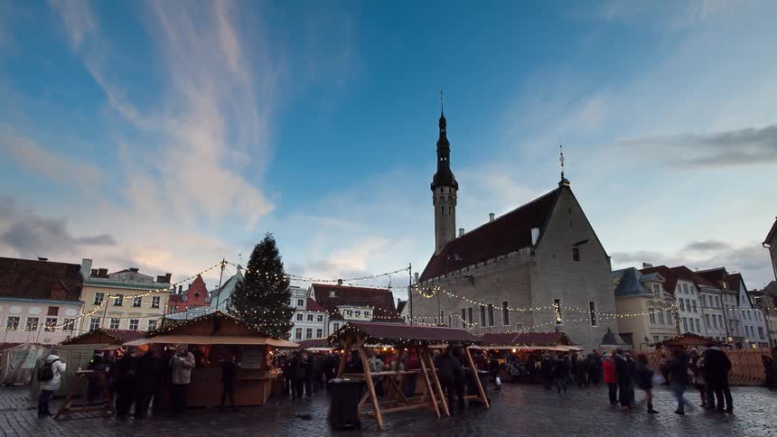 Pedestrians walk in a town at sunset