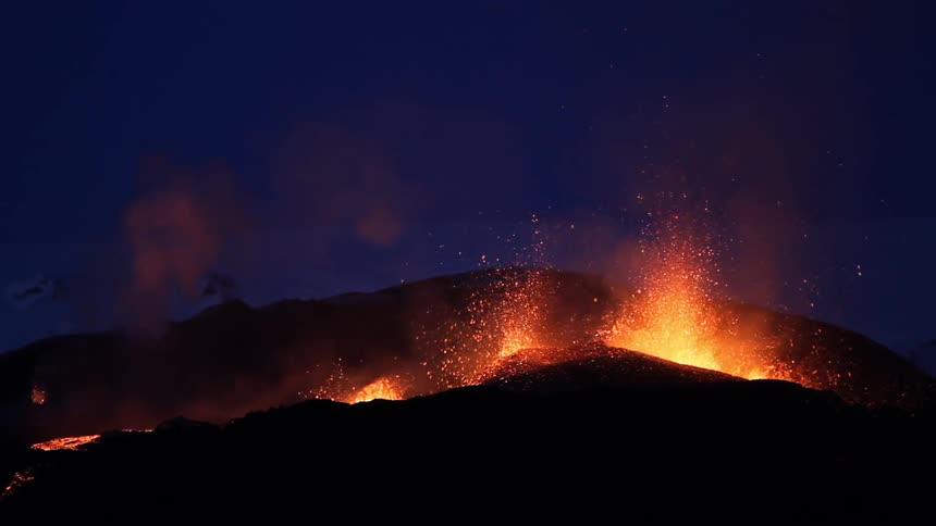 The volcano is erupting with lava at night