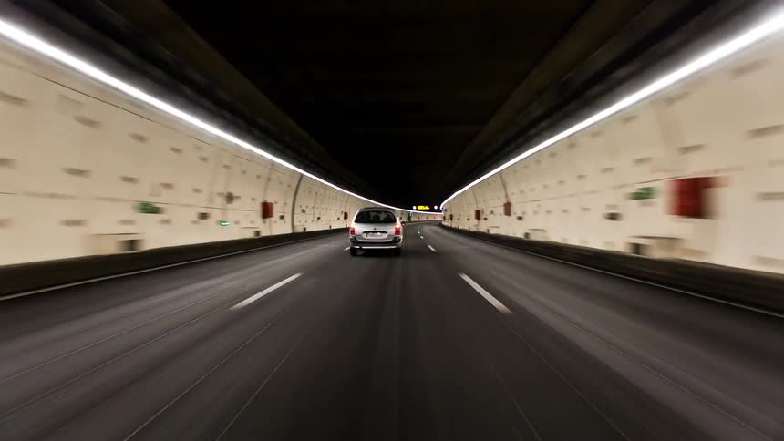 Cars drive through a tunnel