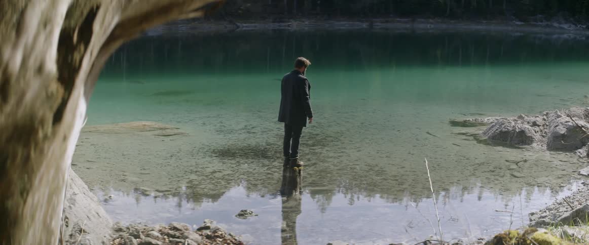 A man stands on a rock in a lake