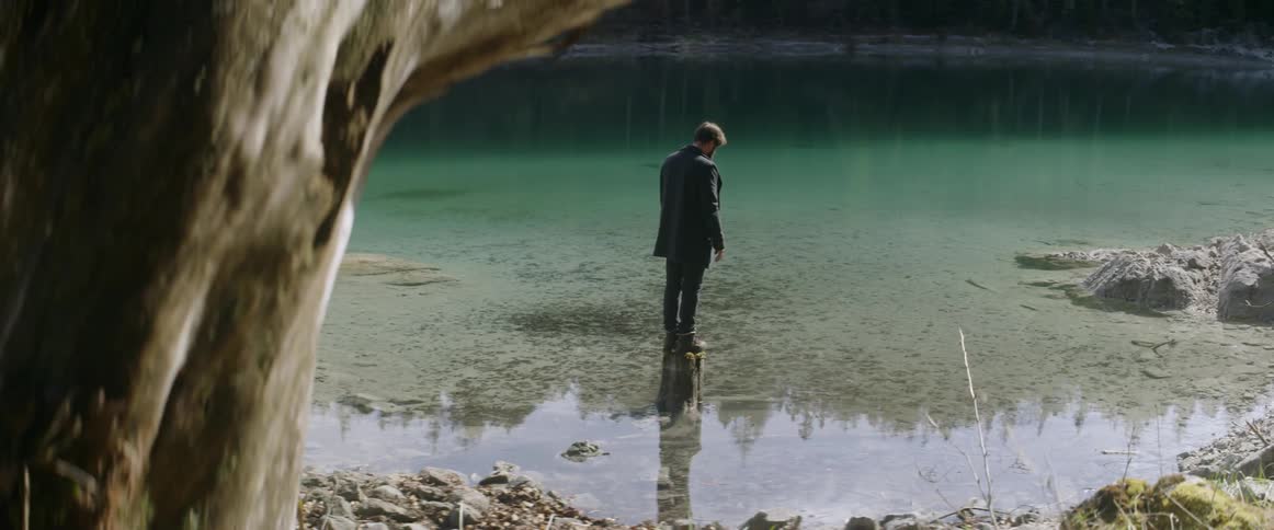 Man standing in shallow water on a cloudy day