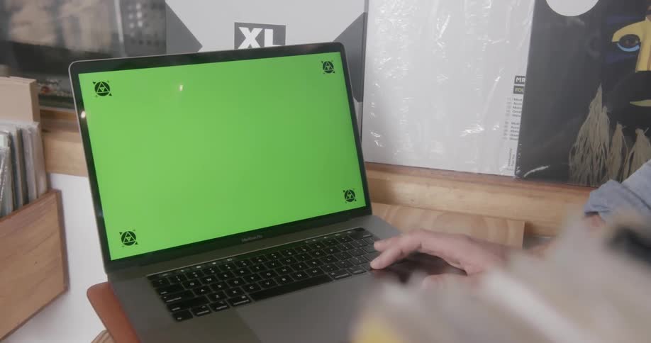A man is working at a laptop in a record store